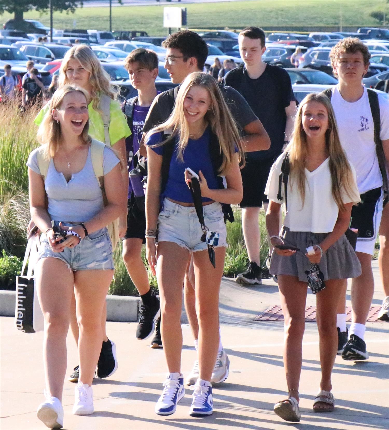 Students smile walking into their school building